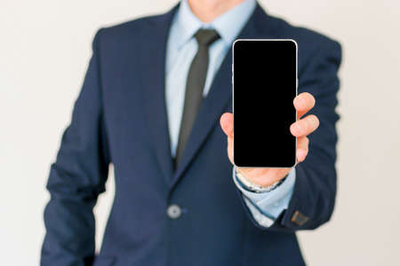 Businessman show his smart phone, smart phone in the handの写真素材