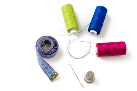Sewing accessories and threads on white, top view