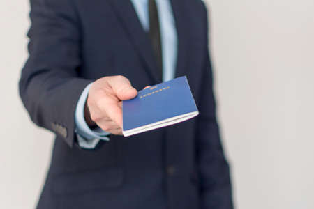 Close-up of a businessman handing over his passport.の写真素材