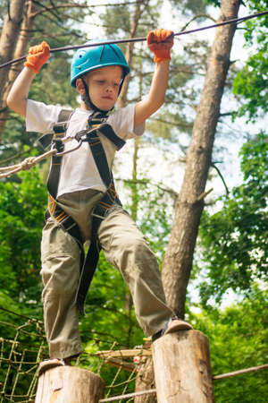 boy at climbing activity in high wire forest park