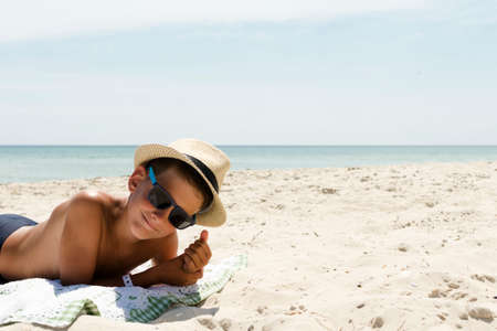 profile portrait of teenager boy in hat on beach
