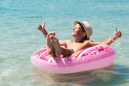 Relaxing boy in inflatable ring in sea.