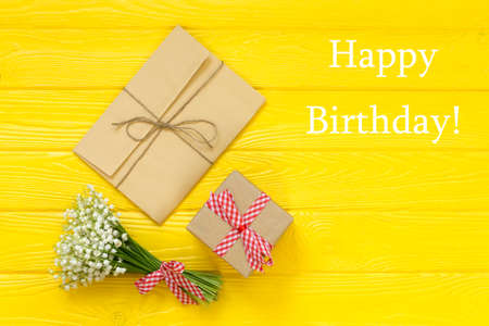 Birthday greeting card and flowers on wooden background