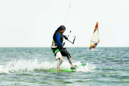 Kitesurfing Kiteboarding action photos man among waves quickly goes.