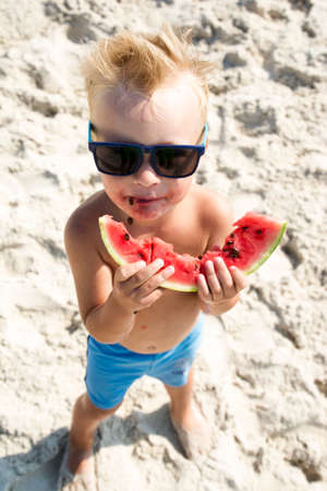 28.08.2018 Lazurne, Ukraine. Cute boy eating watermelon on beachのeditorial素材