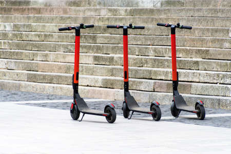 Electric scooters in row on the parking lot. City bike rental system, public kick scooters on the...