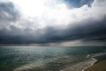 Amazing sky before the rain over sea. Bright glare on the sea before the storm