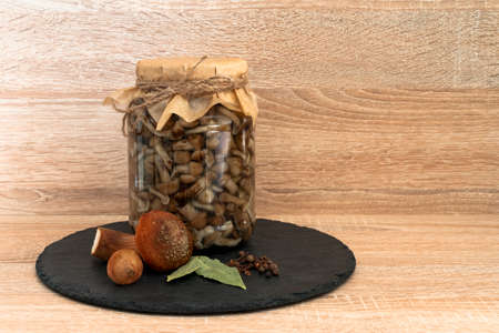 Marinated honey mushrooms in a bowl on the plateblack. On wooden background.の写真素材