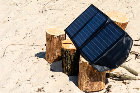 Portable solar panels lie on an wood and accumulate energy.