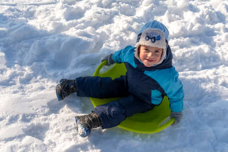 Cherkasy, Ukraine -01.05.2019 Portrait of boy sitting on the sleigh and smiling at the camera