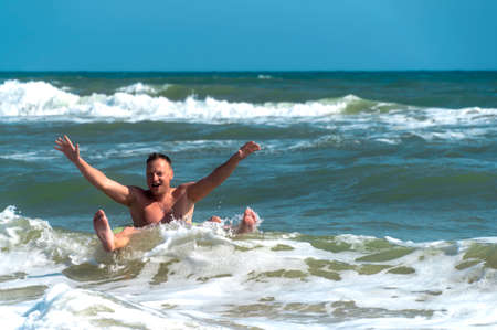 Man have a fun in big Sea wave. Riding on waves in the ocean. Man hit by wave at sea.の写真素材