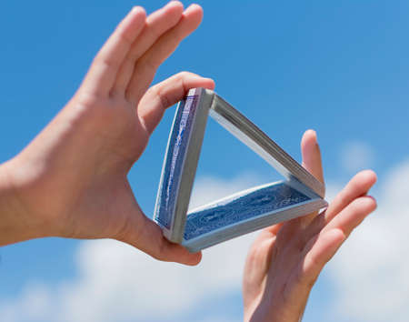 Hand and playing cards over sky backgroundの写真素材