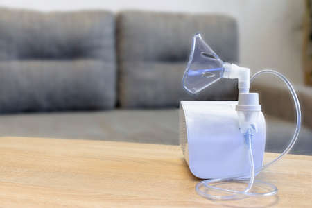 Medical equipment for inhalation with respiratory mask, nebulizer isolated on blur room background. Respiratory medicine. Bronchitis, asthmatic health equipmentの写真素材