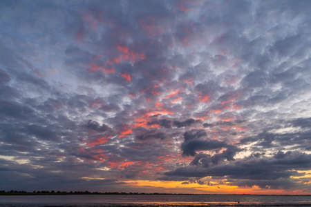 Nice landscape with sunset on lake, fire in sky