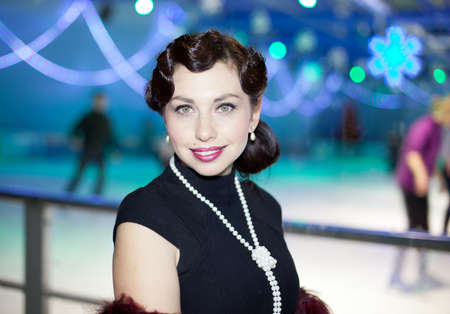 Retro Woman portrait. Young beautiful brunette in black dress looking at camera