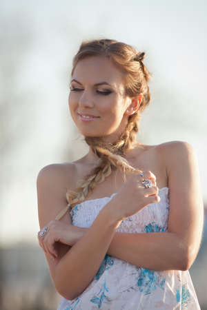 Girl in sundress. Portrait of woman with pigtails on open air
