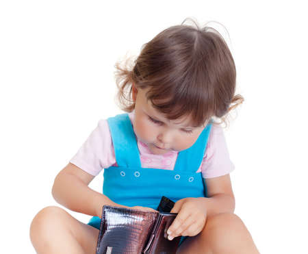 Little girl looking in a purse. Girl with purseの写真素材
