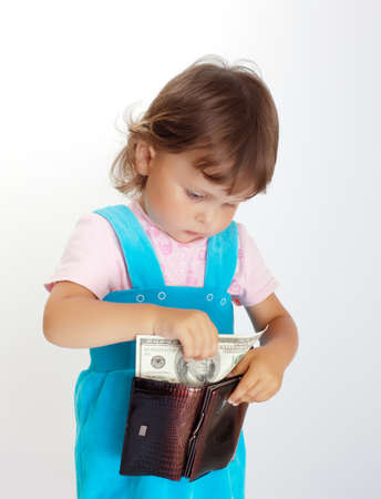 Young buyer. Little girl takes one hundred dollars USの写真素材