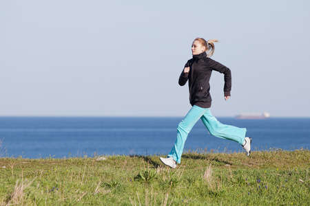 Jogging  Slim girl runs along the seashoreの写真素材