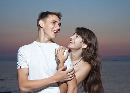 Attractive couple at the sea  Young heterosexual couple flirting on seashore in evening time