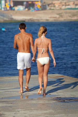 Attractive couple at the sea  Young man and woman on seashore in day timeの写真素材