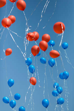 Balloons  Lots of red and blue balloons on the sky backgroundの写真素材