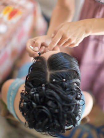 Preparation of the bride for the wedding  Top view of the head of bride and hands of a stylist の写真素材