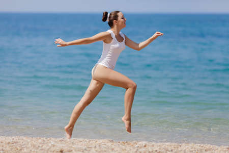 Girl at the sea  Young woman in white hiding her torso smiling	の写真素材