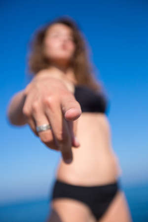 Curly hair girl point a finger. Focus on foregroundの写真素材