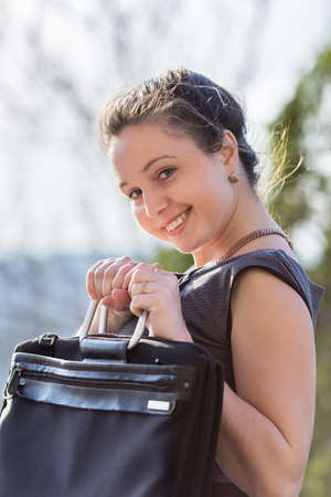 Young business woman outdoors. Girl in gray suit with laptop looking at camera smilingの写真素材
