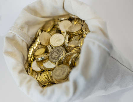 Bag of coins on a white background. Sack with full russian coin of 10 rubles in itの写真素材