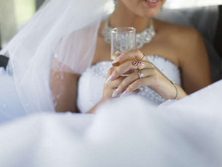 Bride holds wine glass in time of wedding ceremonyの写真素材