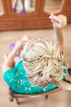 Top view of blonde woman during hair styling