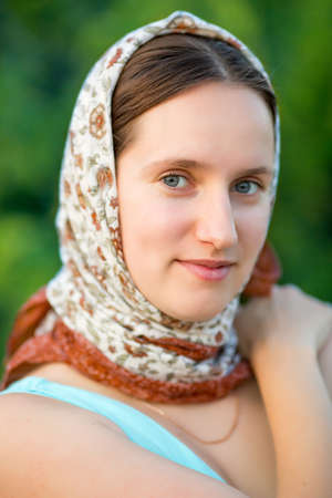 Girl in the park. Young woman in a headscarf without makeup posing on open airの写真素材