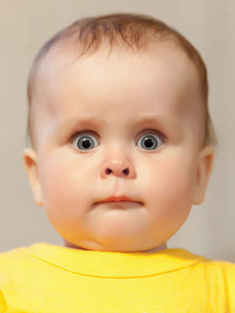 Portrait of an adorable baby. Cute baby girl intently and surprised looks at the cameraの写真素材