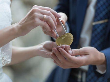 Wedding ceremony with padlock. Newly wedded with decorated padlock of love in the shape of heart の写真素材