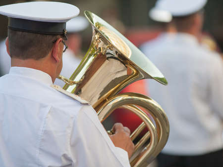 Brass band musician. Musician of a military orchestra with bass brass tuba on parade, rear view