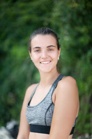 Portrait of attractive smiling girl in bikini top outdoors. Young female person in swimsuit looking at camera smilingの写真素材