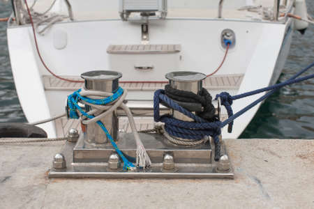 Knecht on old pier. Two-headed mooring bitt wrapped with ropes