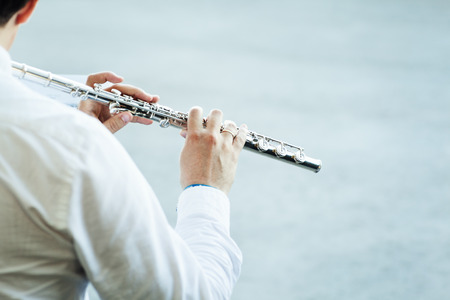 musician playing flute on a neutral backgroundの写真素材