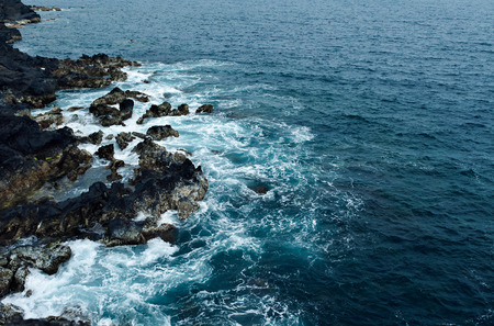 sea waves breaking on rocks with splashesの写真素材