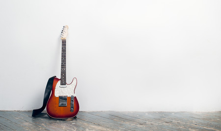 Electric guitar is against white wallの写真素材