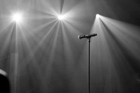 microphone on stage with spot light beams on the backgroundの写真素材