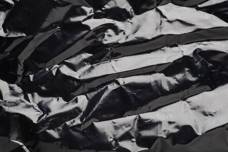 black crumpled plastic bag close up texture backgroundの写真素材