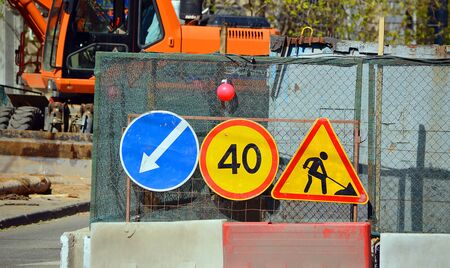 Road signs "Detour obstacles on the left", "Maximum speed limit" and "Road works" on the repair and construction work on the streetの写真素材