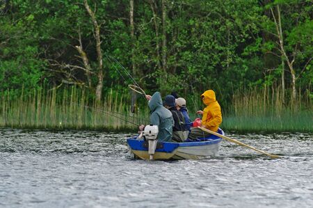 CASTLEBAR, IE - CIRCA MAY, 2011 - Four people fishing from a boat in a lake in Irelandのeditorial素材