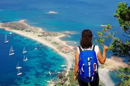 Female hiker (young adult) on the trail to the summit of Tavolara, lookng down towards the sea below.の写真素材