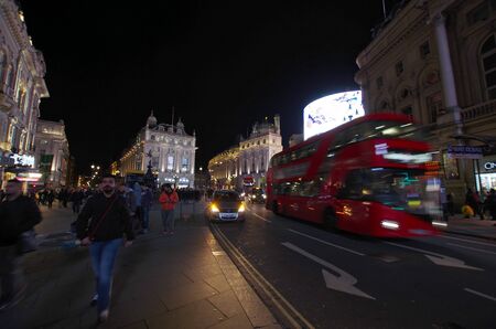 LONDON,UK - CIRCA OCT 2017 - Tourists and the typical red bus near Piccadilly Circus.のeditorial素材