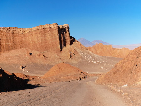 The incredible red rocks of the Moon Valley (Valle de la luna) near San Pedro De Atacama at sunset, with andean volcano Licancabur in the distance. Atacama desert is known as the driest place on earth.の写真素材