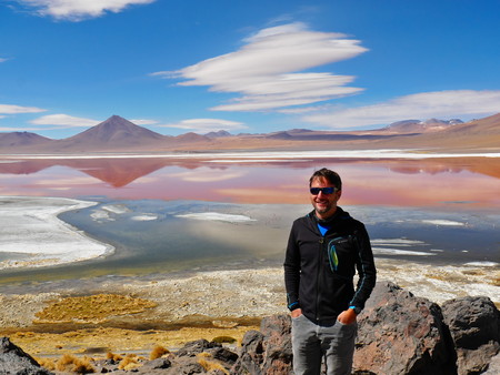 Young male tourist at Laguna Colorada, Coloured Lagoon, takes it's colour from algae and it's populated by thousands of flamingos. Andean altiplano of Bolivia, South Americaのeditorial素材